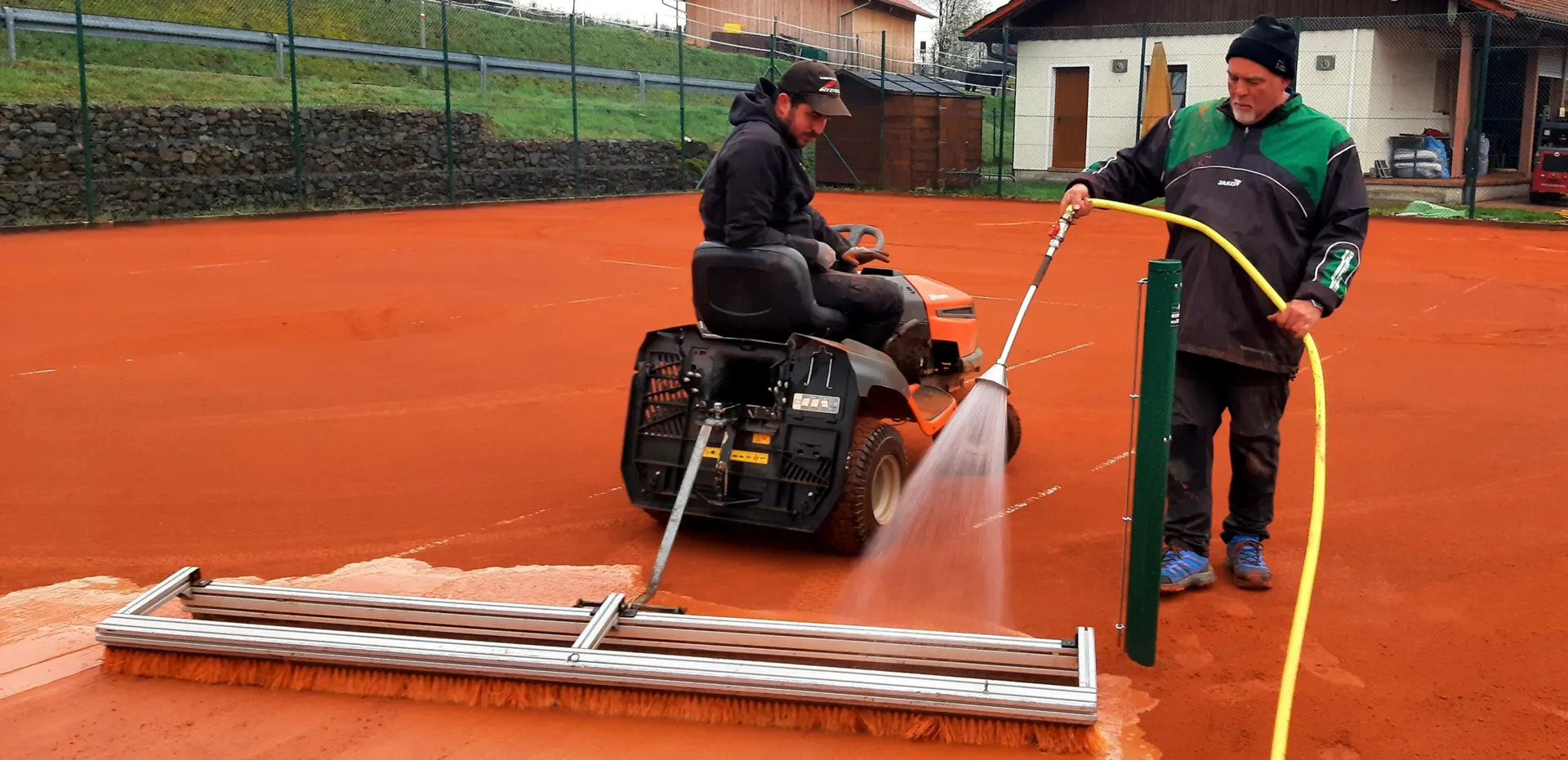 Einschlämmen der Tennisplätze mit reichlich Wasser